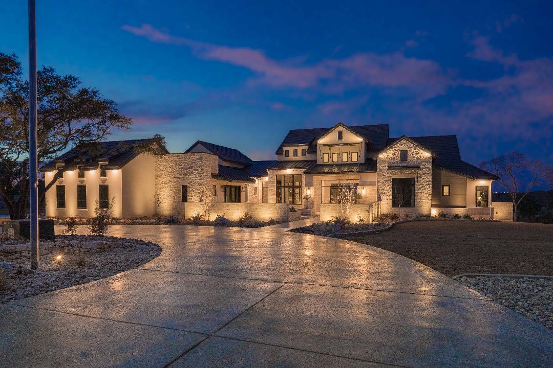 Landscape lighting illuminating a Central Texas home at dusk